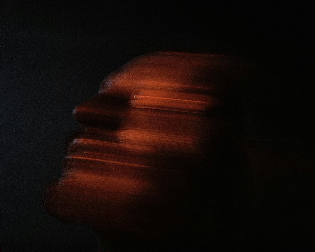 Ethereal abstract blurred portrait on a dark background, capturing movement and mystery.
